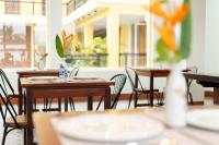 een leeg restaurant met tafels, stoelen en ramen bij Sunflower Angkor Boutique Hotel in Siem Reap