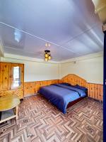 a bedroom with a bed and a wooden floor at Bayith Inn,dragon chowk in Manāli