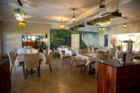 a dining room with tables and chairs and a painting at Kasambabezi Lodge in Victoria Falls