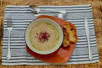 a bowl of soup and some bread on a plate at Kasambabezi Lodge in Victoria Falls