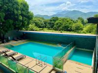 Una piscina con sillas y montañas al fondo. en Hotel El Bosque Valledupar, en Valledupar