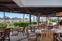 a restaurant with tables and chairs and a view of the ocean at Club Regina Puerto Vallarta in Puerto Vallarta