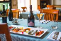 a table with a plate of food and a bottle of wine at Szerb Boutique Suites, by BQA in Budapest