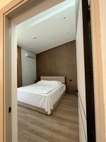 a bedroom with a white bed and a wooden floor at Prince Hotel Kapan in Kapan