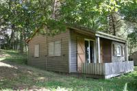 a small cabin in the woods with a porch at La Ptite Ferme de Caro in Meyrignac-lʼÉglise