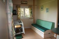 a small room with a bed and a window at La Ptite Ferme de Caro in Meyrignac-lʼÉglise