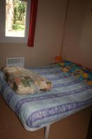 a bed with a quilt on it in a bedroom at La Ptite Ferme de Caro in Meyrignac-lʼÉglise