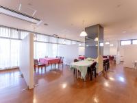 Una sala grande con mesas, sillas y una pizarra. en Omagari Empire Hotel, en Daisen