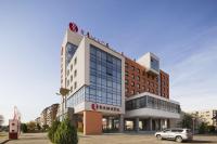 オラデアにあるRamada by Wyndham Oradeaの建物の前に車が駐車されている