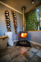 Una habitación con chimenea en una habitación con botellas de vino. en Fairy Knowe Hotel, en Wilderness