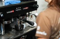 a woman is standing next to a coffee machine at Indie Universe Creative Hotel in Medellín