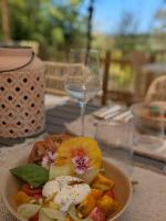 un piatto di cibo su un tavolo con un bicchiere di vino di Nuitées Bohèmes Hôtel & Spa a Gajan