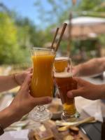 due persone che tengono in mano dei bicchieri di birra su un tavolo di Nuitées Bohèmes Hôtel & Spa a Gajan