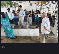 um grupo de pessoas em pé ao redor de uma mesa com potes e panelas em AM Resort em Yelagiri