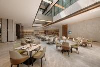 上海梦百合0压酒店（上海虹桥机场国家会展中心店）的一间有桌椅的餐厅