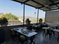 Um restaurante com mesas e cadeiras e uma grande janela. em Near Railway Station Hotel Imperial em Ajmer