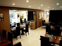 ein Restaurant mit Tischen und Stühlen und einem Weinfass in der Unterkunft Hôtel-Restaurant Belle'man in Longevelle-sur-Doubs