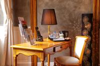 a desk with a lamp and a chair in a room at Hotel D&#39;haussonville in Nancy