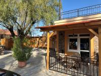 eine Terrasse mit einem Tisch und Stühlen neben einem Gebäude in der Unterkunft Irány Colorado Camping in Nyíregyháza