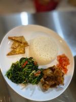 ein weißer Teller mit Essen mit Reis und Gemüse in der Unterkunft Oeseli Beach Bungalow in Pulau Helihana