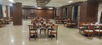 a dining room with tables and chairs in a restaurant at Vivotel Hotel Surat in Surat