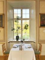 a dining room with a table and a window at Holckenhavn Slot in Nyborg