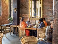 un grupo de personas sentadas en una mesa en un restaurante en ONOMO Hotel Waterfront, en Ciudad del Cabo