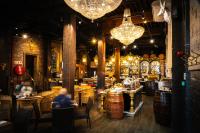 Un restaurante con barriles y gente sentada en mesas. en ONOMO Hotel Waterfront, en Ciudad del Cabo