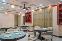 una sala da pranzo con tavoli, sedie e una lavagna bianca di Hotel Relax Suites FNG Expresway 63 Noida a Noida