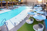ein großer Pool mit Sonnenschirmen und Stühlen in der Unterkunft Hilton Club Elara Las Vegas in Las Vegas