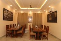 Un comedor con mesas y sillas de madera. en Rang Mahal Ranthambhore, en Sawāi Mādhopur