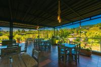 a restaurant with tables and chairs and a view at Hotel Bambu Guatape in Guatapé