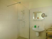 a bathroom with a shower and a sink and a mirror at Hotel Gasthof Goldener Hahn in Frankfurt Oder