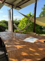 帕洛米诺La Mona Eco Cabins的天井上配有一张带吊床的木桌