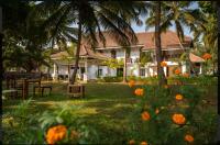 a house with palm trees and flowers in the yard at The Postcard Cuelim, Goa in Cansaulim