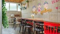 eine Bar mit Stühlen und einer Theke mit einem Gemälde an der Wand in der Unterkunft Gangneung ggabinejip hanok pension in Gangneung