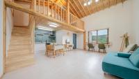 ein Wohnzimmer mit einer blauen Couch und einer Küche in der Unterkunft Gangneung ggabinejip hanok pension in Gangneung