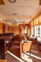 een eetkamer met houten tafels en stoelen bij Haus Strandperle in Zinnowitz