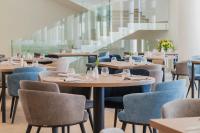 een restaurant met houten tafels en blauwe stoelen bij Monumenti Heritage Hotel&Resort in Pula