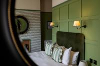 1 dormitorio con 1 cama con paredes verdes y 2 lámparas en The London &amp; Paris Hotel, en Folkestone