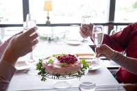 Un groupe de personnes assises à une table avec un gâteau dans l'établissement Keurusselän lomamökit, à Keuruu