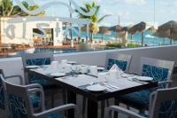 Una mesa con sillas y una mesa con vista al mar. en Club Regina Cancun, en Cancún