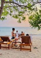un grupo de personas sentadas en una mesa de picnic en la playa en Thani Ecobeach Barú, en Playa Blanca