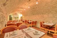 a restaurant with tables and chairs and a stone wall at 121 Paris Hotel in Paris