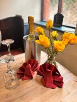 een tafel met een vaas van gele bloemen en wijnglazen bij Kings Arms pub in Cleobury Mortimer