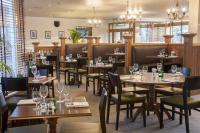 Un restaurante con mesas y sillas de madera y ventanas. en Holiday Inn York by IHG, en York