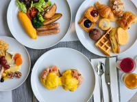 vier weiße Teller mit verschiedenen Arten von Lebensmitteln darauf in der Unterkunft Courtyard by Marriott Bangkok Suvarnabhumi Airport in Lat Krabang