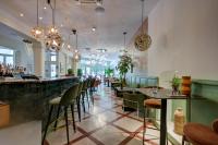 un restaurante con sillas verdes y un bar en Urban Style Hotel Blason du Ventoux, en Carpentras