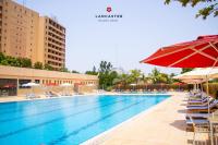 una gran piscina con sillas y sombrillas en Lancaster Ouaga 2000, en Ouagadougou