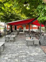 a restaurant with tables and chairs and a red canopy at Gasthof zur Saline in Pratteln